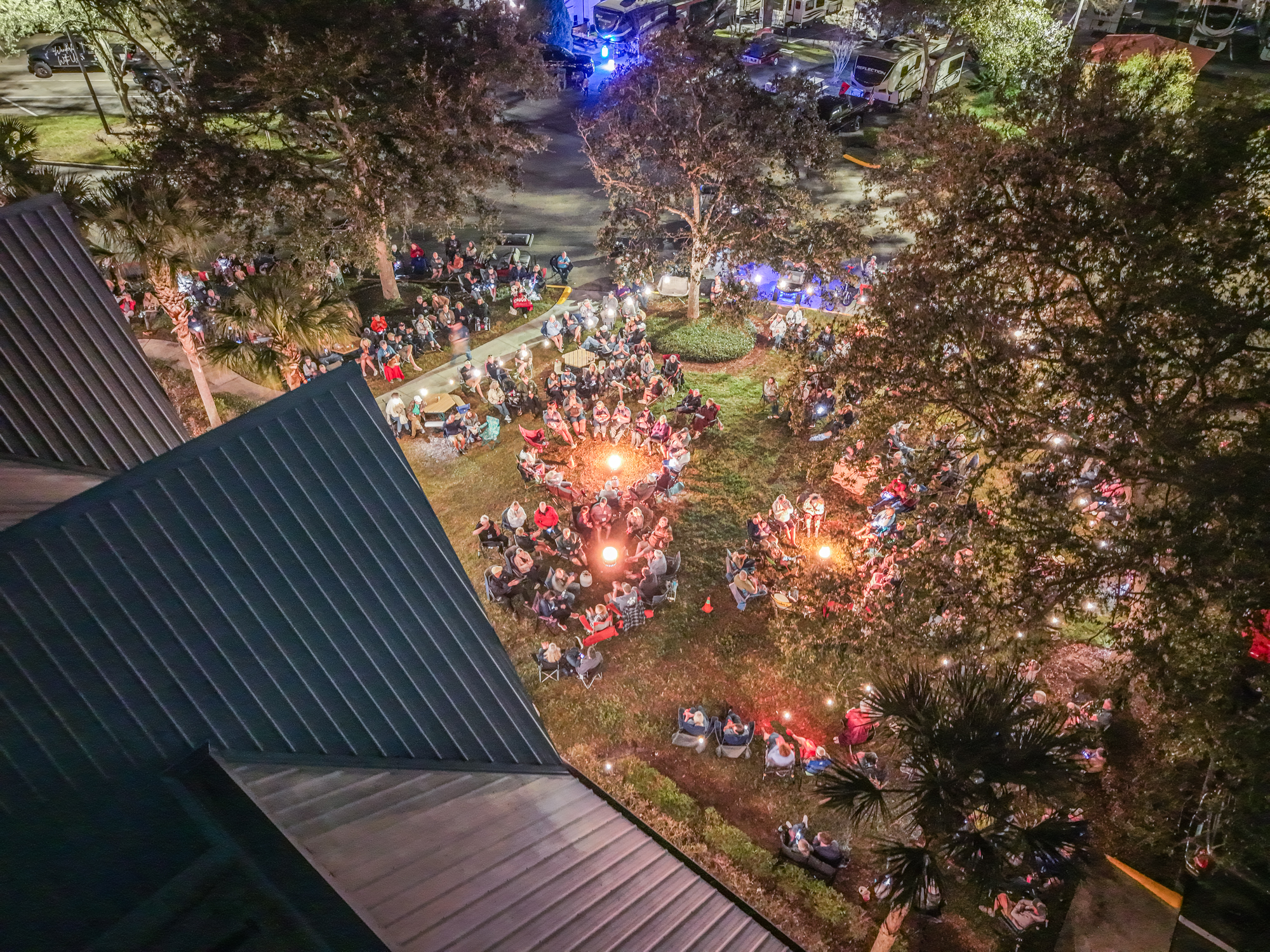 Aerial view of the Tampa Campout campground gathered around campfires at night